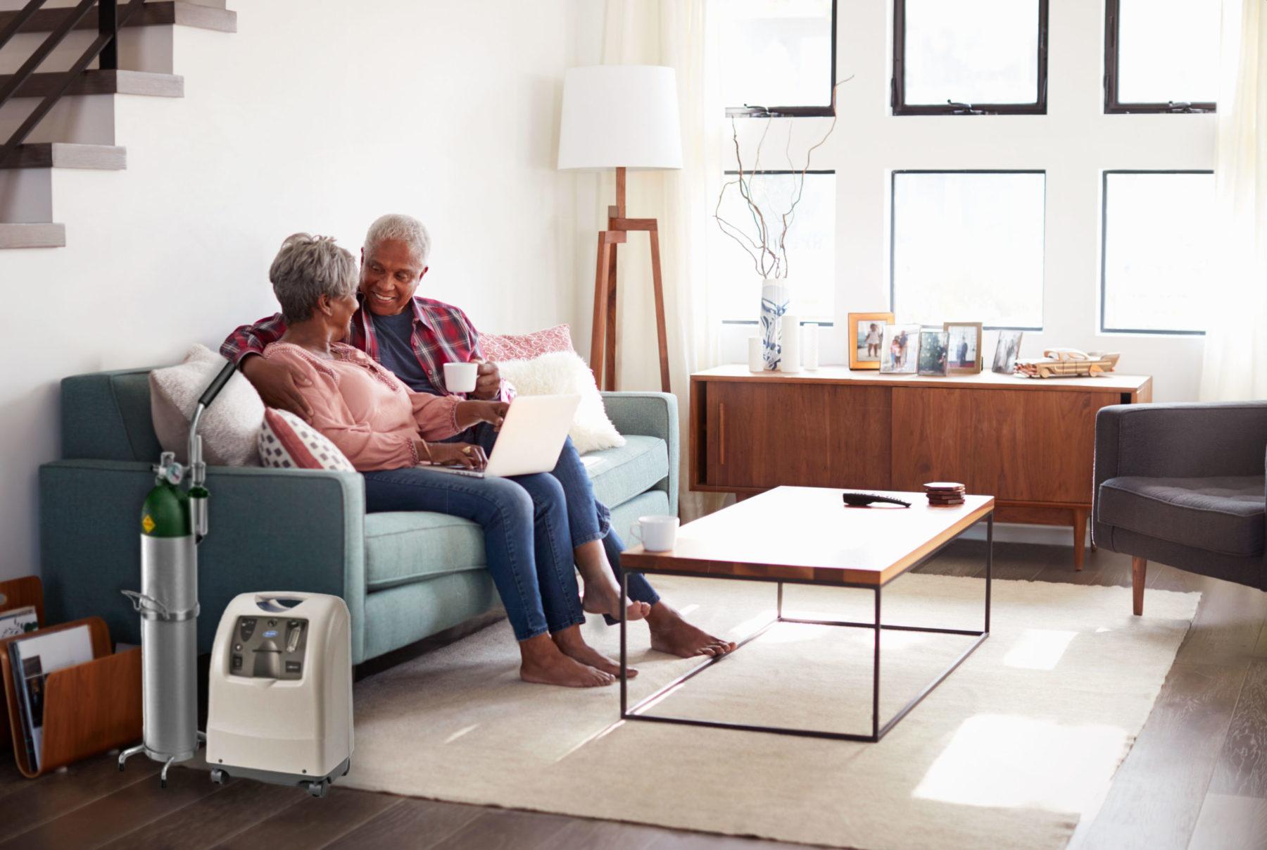 A couple enjoying each other's company on their couch while using an oxygen compressor.